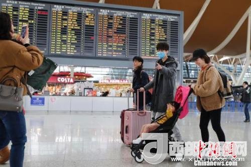 旅客帶著孩子前往辦票柜臺(tái)辦理登機(jī)手續(xù)?！∫罅⑶?攝