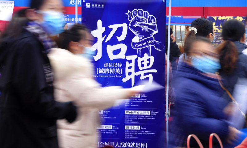 求職者從一家招聘企業(yè)的廣告牌前走過(guò)。新華社發(fā)（苑立偉 攝）