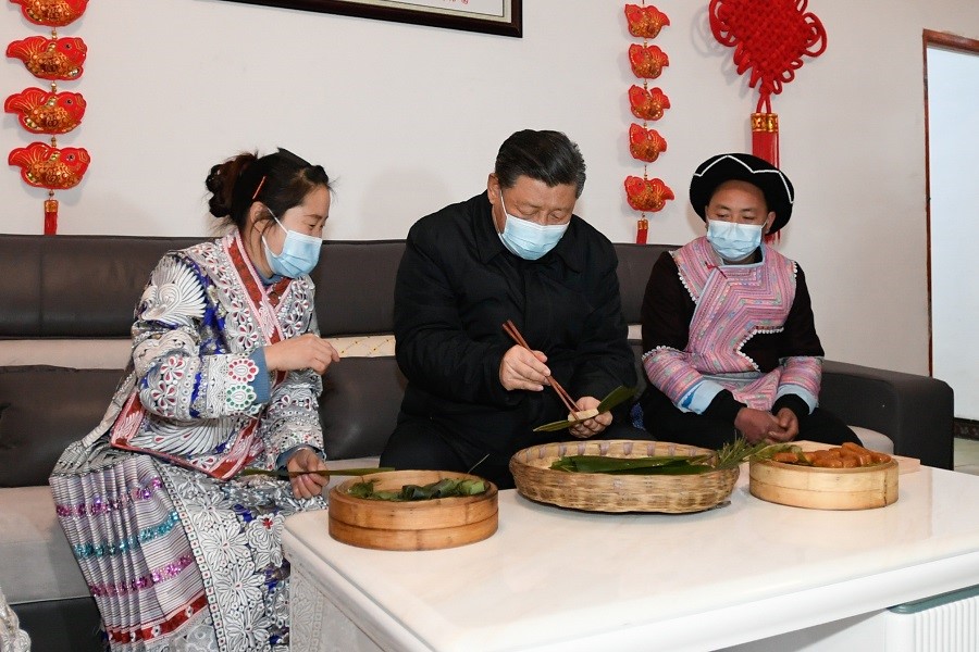 2021年2月3日下午，習(xí)近平在貴州畢節(jié)市黔西縣新仁苗族鄉(xiāng)化屋村苗族村民趙玉學(xué)家，同一家人邊聊家常邊制作當(dāng)?shù)貍鹘y(tǒng)節(jié)日食品黃粑。新華社記者 李學(xué)仁 攝