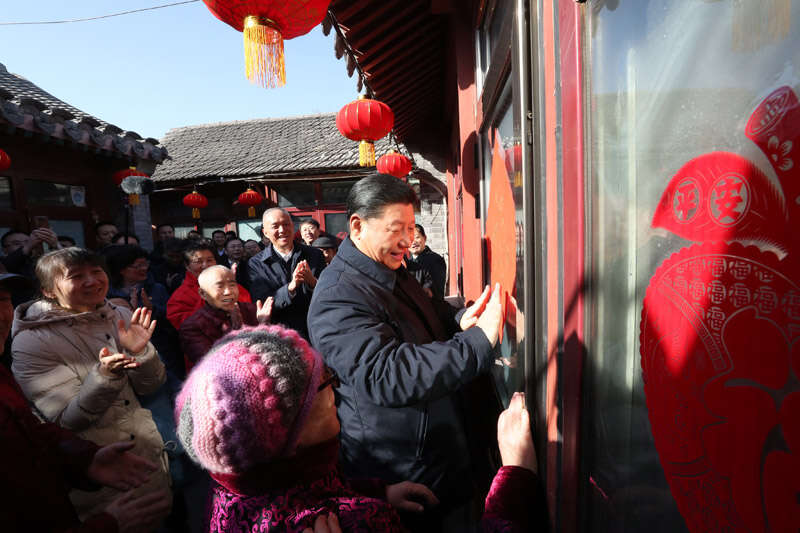 2019年2月1日上午，習(xí)近平在北京前門東區(qū)草廠四條胡同32號院，高興地拿起一幅“?！弊郑H自貼到門上，給這里的老街坊們拜年。新華社記者 鞠鵬 攝